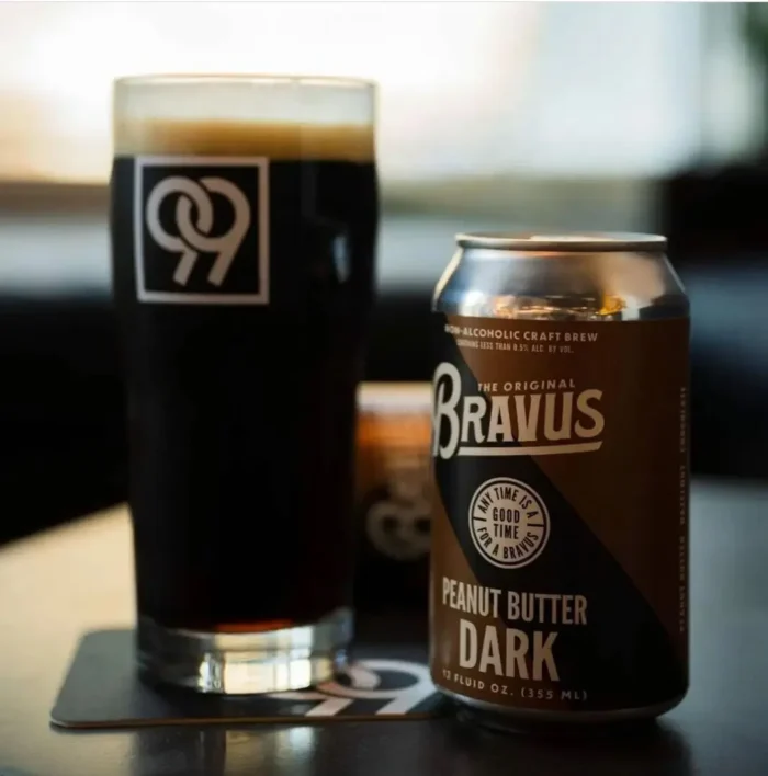 Bravus Peanut Butter Dark non-alcoholic beer can paired with a glass of rich, dark beer, showcasing a bold and flavorful craft brew experience.