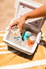 Chilled Athletic Brewing cans ready for a refreshing day at the beach – ultimate non-alcoholic refreshment