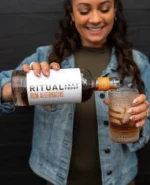 Pouring Ritual Zero Proof Rum Alternative over ice for a refreshing mocktail experience.