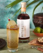Ritual Zero Proof Rum Alternative with a tropical drink garnished with lime, ideal for mocktail lovers.