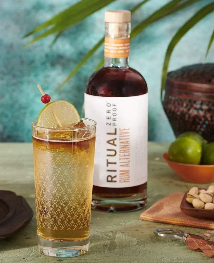 Ritual Zero Proof Rum Alternative with a tropical drink garnished with lime, ideal for mocktail lovers.