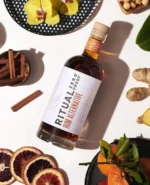 Ritual Zero Proof Rum Alternative surrounded by fresh ingredients for creative, alcohol-free cocktails.