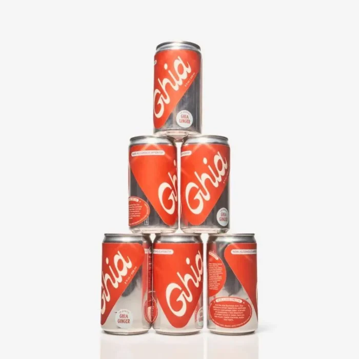 Ghia Ginger cans stacked in a pyramid formation with bold red and white branding on a white background.