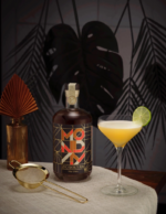 Monday Zero Alcohol Spirit with a tropical cocktail garnished with a lime slice, set against a chic background.