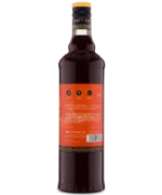 Back view of a tall glass bottle with a red label and dark liquid, ideal for gourmet drinks or cocktails.