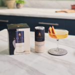 Savile non-alcoholic drink can, box, and a garnished cocktail glass on a marble kitchen countertop.