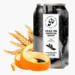 Can of Go Brewing's Head On American Wheat non-alcoholic beer, paired with wheat stalks and orange peel, showcasing its citrus and grain-forward flavor profile.