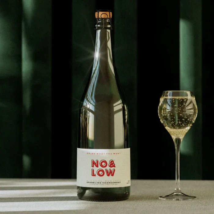 No & Low sparkling wine bottle with a glass in a minimalist and elegant setting."