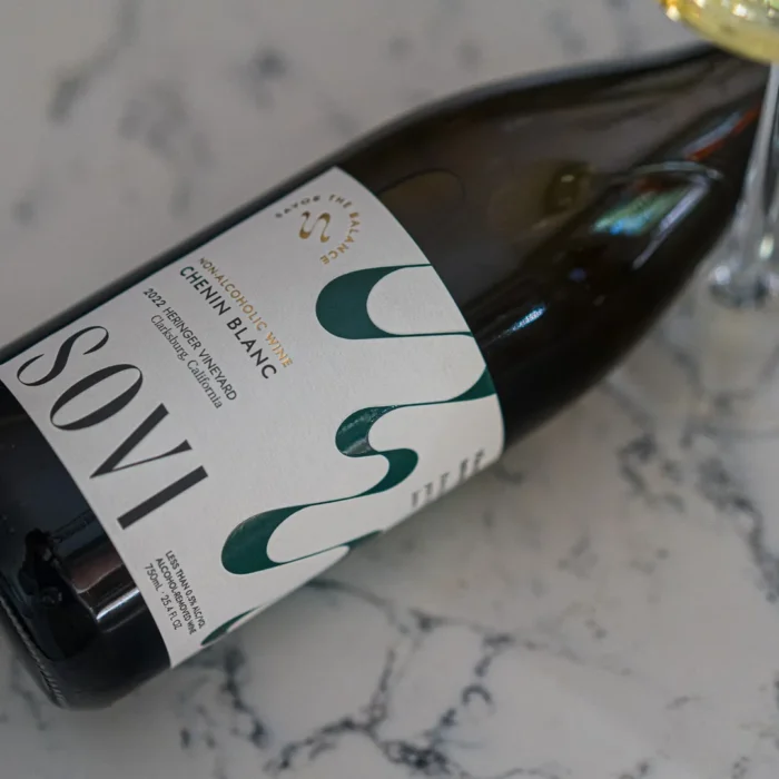 Close-up of a Sovi Chenin Blanc bottle lying on a marble surface, highlighting its elegant label design.